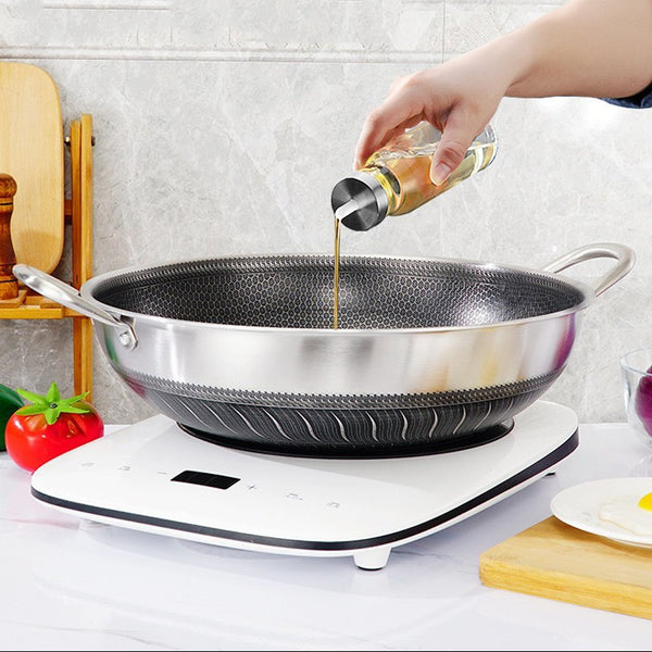Person pouring oil into a wok on a stove with kitchen utensils in the background